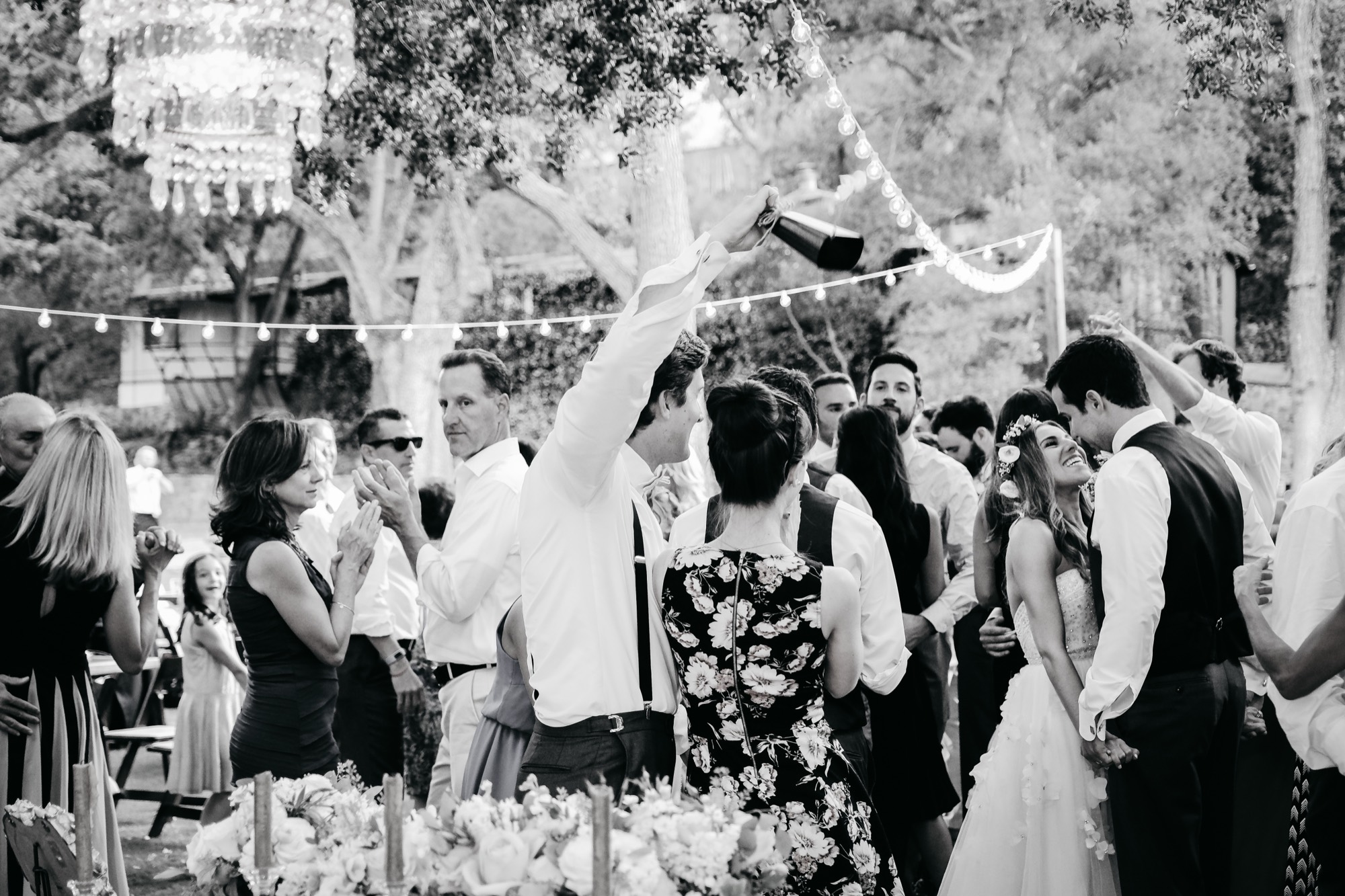 Guests celebrating with champagne at a wedding reception, in black and white